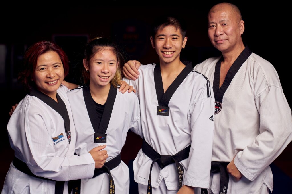 A smiling family posing together in their uniforms to highlight community connection and mental well-being through training.