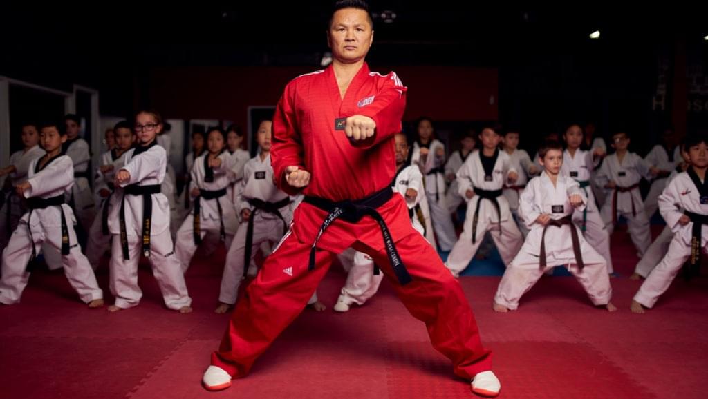 A high-ranking master performing a lead punch during a black belt to demonstrate perfect martial arts technique.